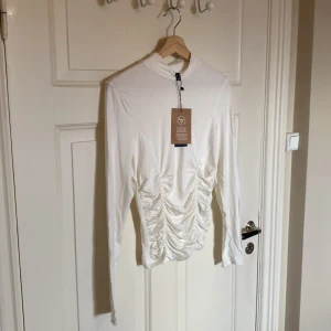 Snygg topp från Vero Moda - Säljer denna snygga toppen från Vero Moda. Storleken är M, passar S bättre. Helt ny! Snygga detaljer på magen. Nypris 229.95kr