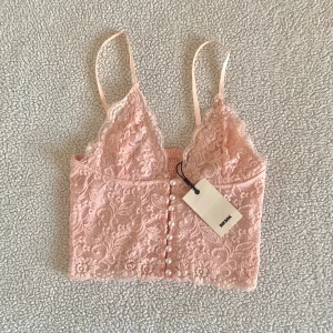 BikBok rosa spetslinne / spetstopp med pärlknappar - Gullig spetstopp från BikBok med pärlknappar. Ny med tags kvar, utan anmärkningar.