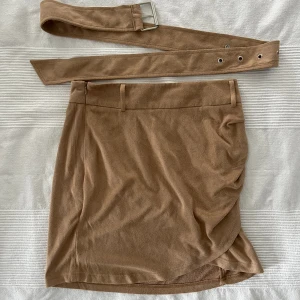 Linn Ahlborg x Nakd mockakjol - Mockakjol från Linn Ahlborgs samarbete med Nakd. Finns dragkedja på ena sidan, medföljer bälte som går att dra åt. Använt fåtal gånger, bra skick.