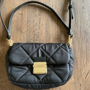 Fin enkel handväska💗 - En enkel och jättefin svart handväska med gulddetaljer. Två olika band som kan tas bort och de långa bandet kan justeras. Från Lindex och är i bra skick💗