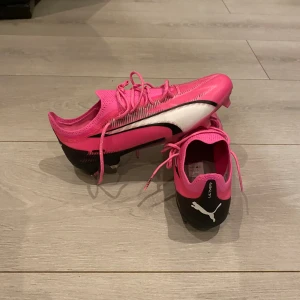 Puma Ultra ultimate FG/AG phenomenal-poison pink vit svart  - Hej jag vill sälja mina fotbollsskor som är helt onanvända och som är senaste modellen 