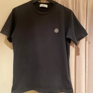 Stone island T-shirt - Säljer en svart Stone island T-shirt i storlek 12 år. Säljes pga för liten. Köpt på Nk i Göteborg. OBS! Finns små hål ( 2 bilden) Nypris 859kr Mitt pris 229kr