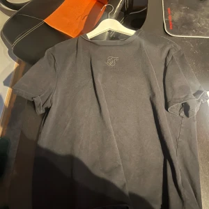 Siksilk T-shirt  - Siksilk T-shirt i svart med baksida text. Använd men bra skick.