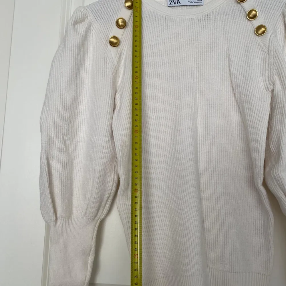 Jättefin vit tröja från Zara med guldiga knappar.  Tröjan är i fint skick, använd Max 2-3 gånger.  Tröjan är I storlek L men liten i storleken så skulle säga den är som M.. Tröjor & Koftor.