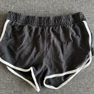 Shorts  - Svarta shorts med vita linjer på kanterna, blivit för små tyvärr.