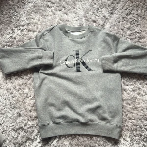 Calvin Klein Jeans Crewneck Sweater Tröja Grå Storlek M - Säljer denna Calvin Klein Jeans tröjan jag haft länge men knappt använt! Den här en riktigt skön insida och passar till 90% av dina outfits. Rekommenderas starkt! Nypris runt 1 tusen tror jag. 10/10 skick, skickas samma dag m instabox!  🟥 Mvh sebbe