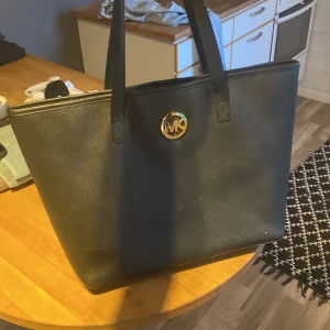Michael kors väska  - Fin, bra skick lite smutsig inuti men jag kan tvätta bort innan jag skickar iväg den. Inga defekter utöver det. Köpt för ca 2000kr
