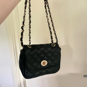 Axelremsväska med gulddetaljer - Snygg axelremsväska med gulddetaljer