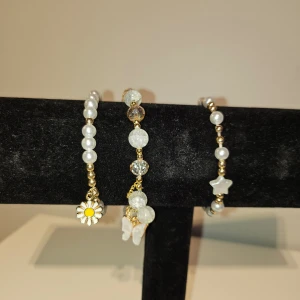 3 st sommar armband  - 3 st sommar armband med pärlor en med en stjärna på en, en med en fjäril på och en med en blomma, aldrig använda.