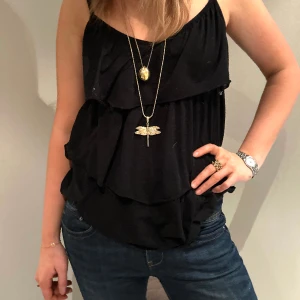 Fest topp - Svart volang topp/linne som passar till både sommaren men också på fest🧚‍♀️ toppen är lite v ringad och har både volang där fram och där bak. Toppen är i nyskick och har inga defekter! Skriv för fler frågor. Frakten kostar 48kr🧞‍♀️ ❗️fri frakt gäller ej❗️