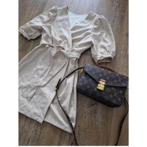 Nakd Na kd Lack klänning omlott wrap skinn skinnklänning pu beige - Coool classy klänning, snygg ringning. Fina detaljer upptill med lätt puffärmseffekt, Omlottskuren. Stretch.  Sitter som en smäck och är helt otroligt bekväm. Färgen är klockren och imitationen är helt otroligt grym