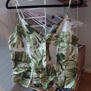 Linne med smala axelnand  - Så fin topp i 100 procent lin. Knappat framtill, reglerbara axelband, cropped modell 