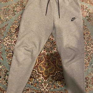 Grå Nike tech byxor  - Helt nya typ. Skick 10/10. Använt de ba 4 ,5 gånger. Köpt för 1200kr typ