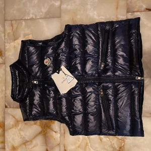 Moncler väst  - Hej! Säljer nu min moncler gui väst. Knappast andvänd och ingen syn på det heller, västen är i storlek 2 och till färg är den mörkblå