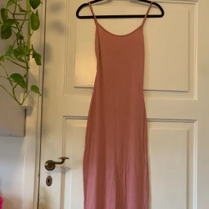 Skimsliknande klänning - Rosa, lång, skimsliknande klänning. Endast använd 2/3 gånger utan synliga defekter. Passar bra på mig som normaltsätt har storlek S, men passar även M.