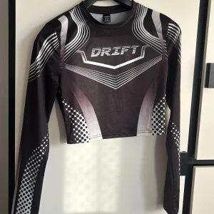Kort sportig tröja - Häftig grå svart kort sportig tröja (Drift). 🩶🖤 Om det önskas kan jag ta fler bilder privat och visa de hur det sitter på♥️♥️