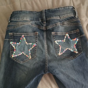 Handsydda utsvänga jeans - Köpta här på plick av en säljare som sytt dessa själv. Så snygga men har tyvärr inte andvänts så mycket😕 baksfickorna går inte att andvända då dem är igensydda av stjärnorna. Midjemått rakt över:35cm(stretch). Jag är 158cm