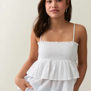 Frill top Gina Young  - En jätte gulligt linne ifrån Gina tricot Young i storlek 146 - 152. Jätte fint skick, däremot håller lappen men storleken på att lossna. Köptes för 199,95kr och säljes för 100kr eller mer beroende på vad vi kommer överens om. 