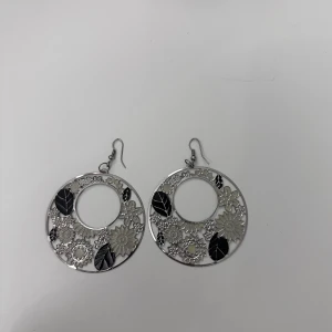 Två par örhängen - Första paret som är silvriga och svarta! Andra paret är lila och silvriga! Aldrig använda!! Rengör alla smycken innan jag skickar dem!!