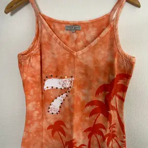 Nytt linne i somrig färg.  Batik-mönster, tryck och paljetter.  Korall-färg som är fin till sommarens solbränna! St. 38/40 Bomull, elastan 