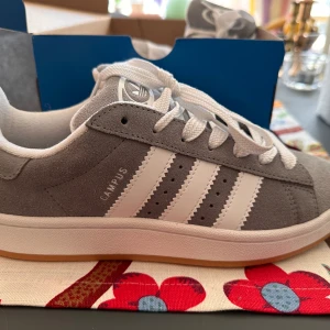 Helt nya/oanvända Adidas Campus 00 grå - Helt nya oanvända gråa Adidas Campus 00 grå i storlek 38 2/3. Kvitto och extrasnören följer med. Säljes pga fel storlek