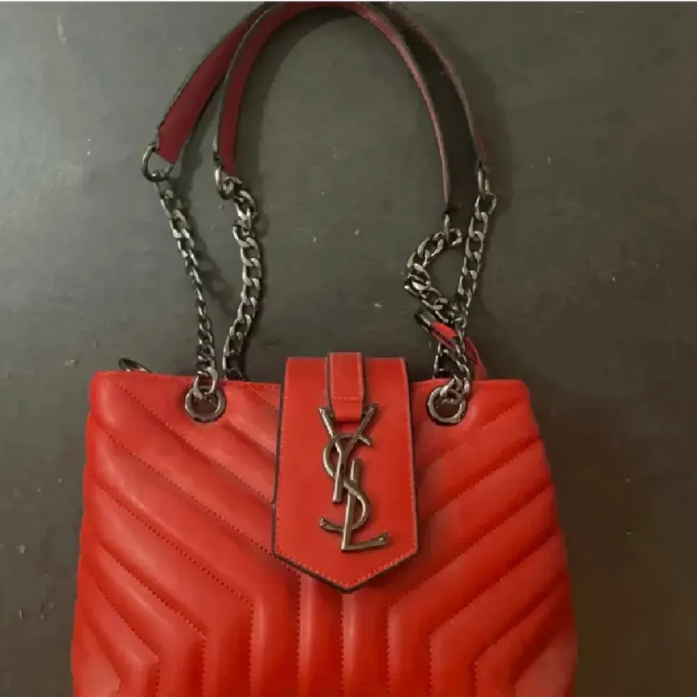En helt ny och oanvänd röd Yves saint Laurent väska, säljer den på grund utav att det inte är min stil längre. Finns inga defekter.. Laukut & Käsilaukut.