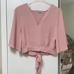 Rosa blus - nyskick💕 - Jättegullig rosa blus, har en knyt på baksidan vilket går att justera beroende på din storlek. Skulle passa alla mellan XS-L💓 helt fin använd, ser helt ny ut. Köpt för 199kr, säljer för 89kr. 