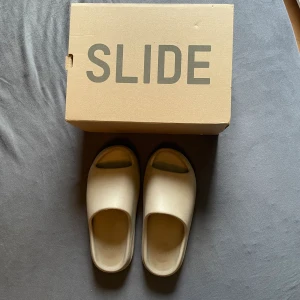 Yeezy Slide Pure - Säljer nu mina äkta Yeezy Slides till ett billigt pris eftersom de har har blivit för små. Det är storlek 46 men har en mindre passform så de kan passa en 44/45