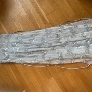 Silver klänning - Hej jag säljer min helt oanvända klänning eftersom har inte fått nån användning av den. Ryggen är öppen med knytning. Köptes för 600 och säljer för 500kr