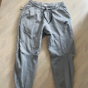 Nike tech byxor  - Hej säljer mina Nike tech byxor då jag aldrig använder dom längre, säljer dom ganska billigt pågrund jag brände knät så sydde ihop de men sins knappt irl.🙂 du kan köpa hela setet för 599😉 Skick är 7,5/10 men bekväma att ha på sig  Frågar bara skicka🤗