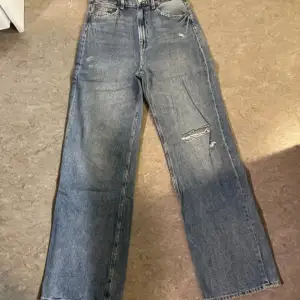 Ett par mörkblåa high waist jeans i storlek 38, köpt på H&m för nått år sedan, jeansen har hål som ni kan se på bilderna, sitter fint där bak
