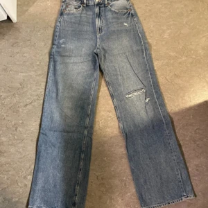 Raka jeans med hål - Ett par mörkblåa high waist jeans i storlek 38, köpt på H&m för nått år sedan, jeansen har hål som ni kan se på bilderna, sitter fint där bak