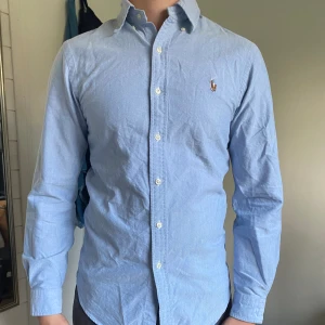 Ralph Lauren skjorta  - Ljusblå skjorta i storlek S, knappt använd. Säljer för att den inte passar längre.  Alla 3 extra knappar finns kvar.