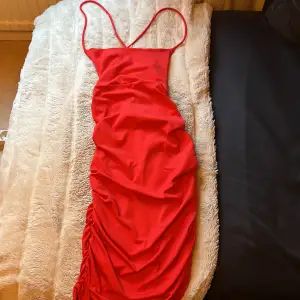 Röd midi klänning som går ner till knäna med snörning i ryggen från BikBok, använd en gång.