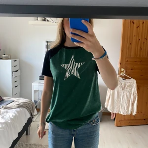 T-shirt med stjärna - Grön och svart t-shirt med en vit stjärna. Använd endast ett fåtal gånger💚 Extremt mjukt material
