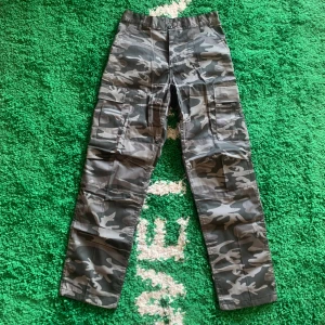 Rothco BDU camo cargos - Sköna Rothco cargos som verkar vara utsålda nästan överallt. Storlek: W27-31 L29,5-32,5. Endast provade, så helt nya. Om någon har storlek medium så byter jag gärna. Skicka ett meddelande innan köp!