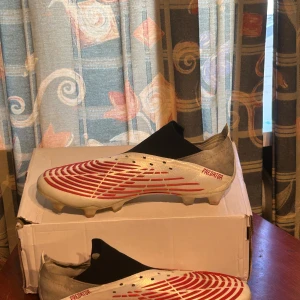 Adidas predator edge white and red - Till salu: Adidas Predator Edge i vitt och rött. Dessa skor är designade för ultimat prestanda på fotbollsplanen med en perfekt kombination av komfort, grepp och bollkontroll. Perfekt för spelare som vill ha överlägsen känsla och precision. 