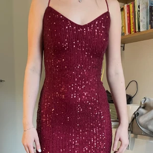 NY lång mörkröd balklänning SHEIN XS - Underbar, lång, mörkröd balklänning i storlek XS. Klänningen är oanvänd med lappar kvar, säljer pga av att den är lte stor i storlek. Klänningen är täckt av finsydda paljetter ton i ton med tyg. Justerbara axelband med knyt i ryggen. Inköpt för 1200.