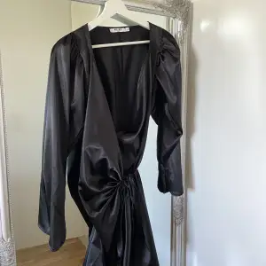 En svart satin klänning som är använd en gång. 