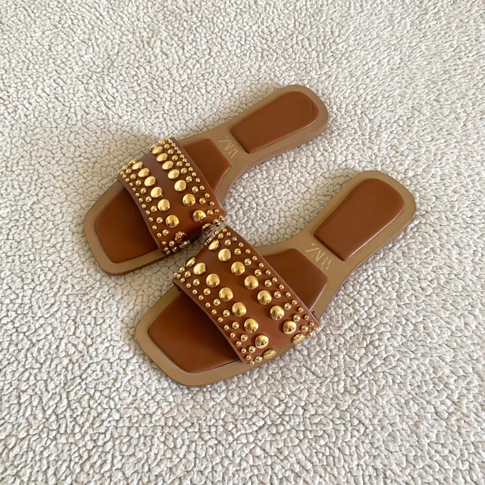 Otroligt snygga sandaler från ZARA med guldiga nitar. Använda två gånger förra sommaren, men fortfarande i mycket bra skick.. Skor.