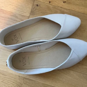Vita ballerina skor - Superfina vit/beiga ballerina skor med spetsig tå! Perfekta till studenten eller skolavslutningen! De är i storlek 37 och i mycket bra skick, en minimal smutsfläck på ena tån, men går antagligen enkelt att få bort! Tyvärr för stora för mig.