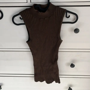 Turtleneck topp - Brun ribbad turtleneck linne från new yorker, storlek XS (stretchigt material). Helt oanvänd. Köparen står för frakt, finns katt i hemmet!