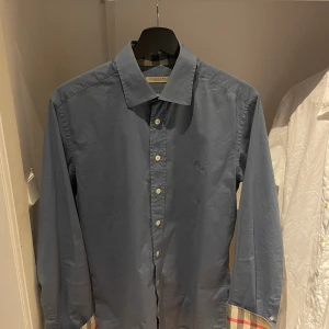 Burberry skjorta - Hej! Säljer nu en svin snygg Burberry skjorta som passar perfekt nu till sommaren! Skjortan är i bra skick, säljer den enbart för den är för liten! Hör av er vid frågor och annat!