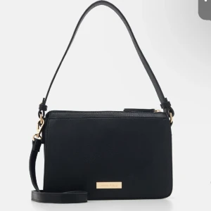 Anna field väska  - En jättefin och elegant väska, med gulddetaljer. Säljer den pga har köpt en liknande. Ny pris: 339kr
