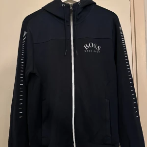Hugo Boss ziphoodie - Säljer min killes ziphoodie, knappt använd då han fick den i julklapp och för liten men han orkade inte att lämna tillbaka/ byta🙃 Nypris 1800