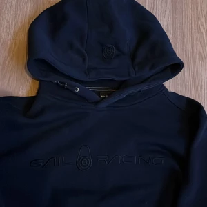 Sail Racing hoodie - Mörkblå Sail Racing hoodie i skick 9,5/10 nästan aldrig använt. Storlek L men funkar även som M. Kan gå ner i pris vid snabb affär