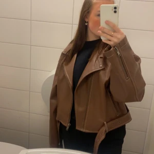 Brun skinnjacka - Säljer min ursnygga skinnjacka från Bianca Ingrossos kollektion med Nelly, då den aldrig kommer till användning. Använd kanske 2-3 gånger Max. Den är lite för stor för mig. 