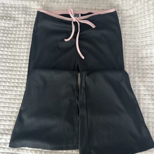 Utsvängda byxor - Säljer dessa sjukt snygga ribbade byxor från Shein. Dem har en jätte gullig rosa rosett på framsidan. Dessa är aldrig använda! Dem är i storlek M men passar S ocksp hade jag sagt❤️🫶🏼