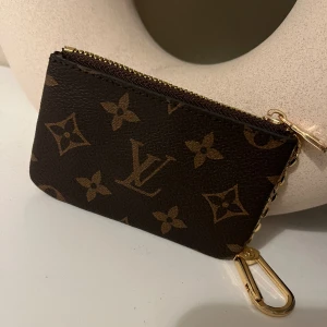 Nyckelhållare  - Nyckelhållare med pouch som man kan ha bla kreditkort m.m i . Fått denna i present så kan inte garantera att denna är äkta, men i så fall mkt välgjord 