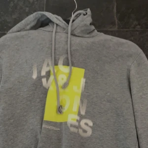 Grå Jack&Jones Hoodie  - Grå Jack&Jones Hoodie som nästan aldrig används, skick: 6/10, snörena är ganska sönder, storlek: M